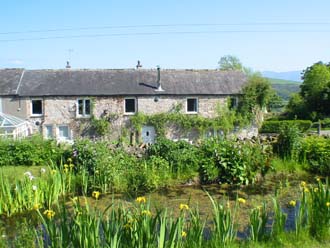 View across the wildlife pond to Huddlestone Cottage and The Hayloft